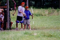 Two scouts at the archery range.  Both are smiling, and facing right.