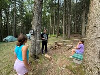 Four people, two of them are inside a ropped off area, two are standing outside.  A sign says 