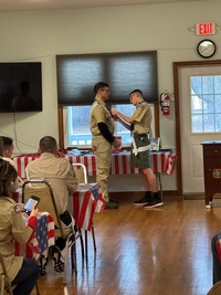 Anthony putting a pin on Scoutmaster Brewer's class A uniform