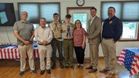 Seven people stand smiling for the camera.