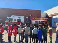 Picture of a firetruck that says 'GREENPORT PUMPER CO. NO. 1 EST. 1927'.  There are several scouts looking at it, with three scouts from Troop 53 on the left of the photo.  The three scouts are wearing their class B hoodies.