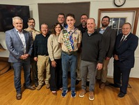 Eleven people smiling for the camera.  Two of whom are in class A uniforms.