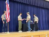 A scout giving an award to another scout.