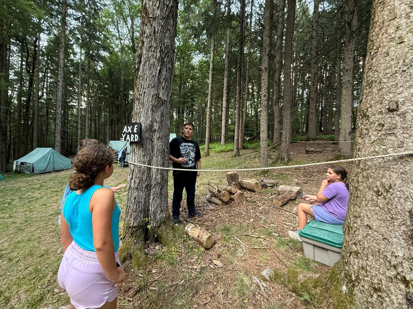 Four people, two of them are inside a ropped off area, two are standing outside.  A sign says 