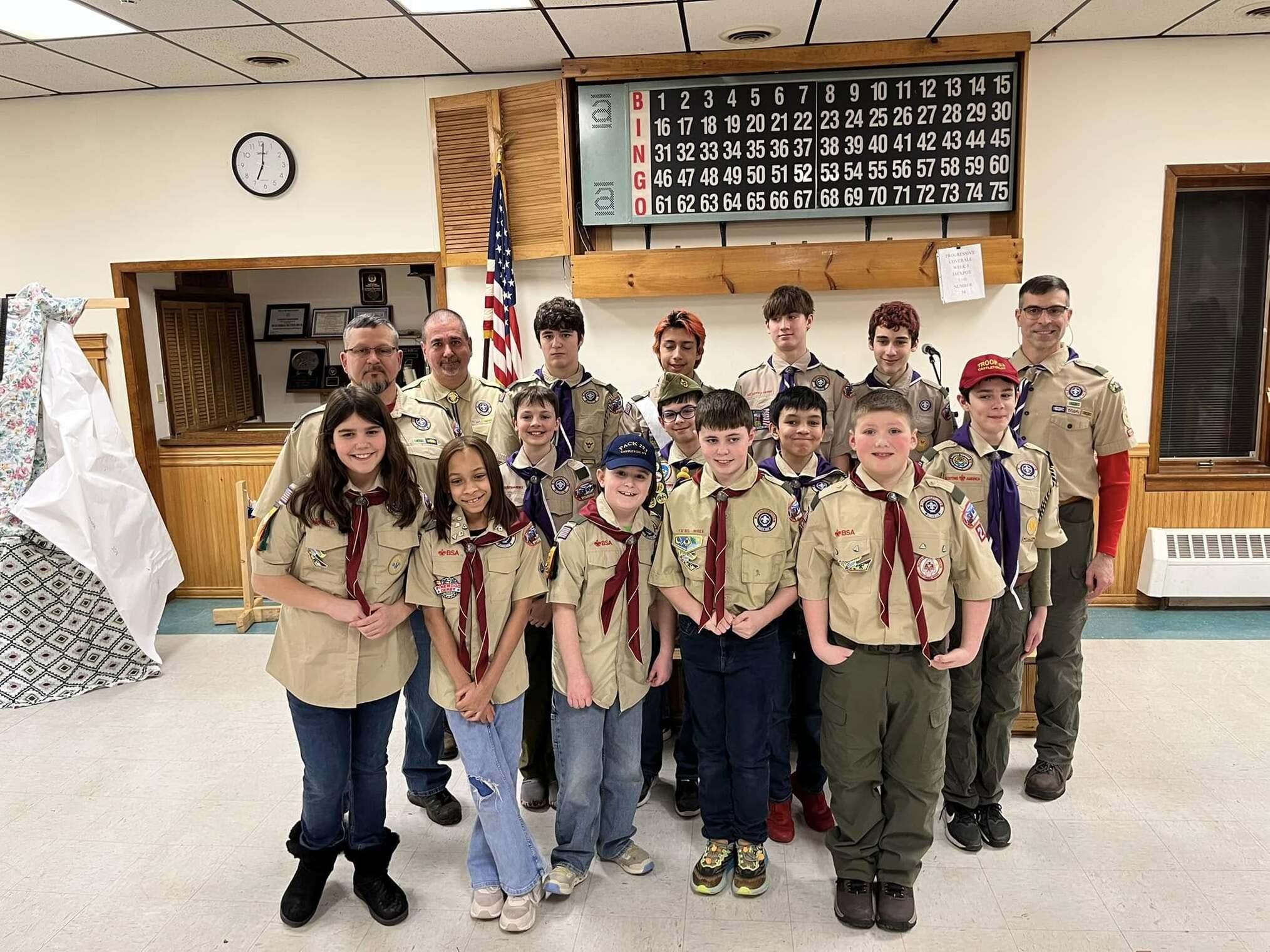 Sixteen scouts and adults wearing class A uniforms smiling at the camera.