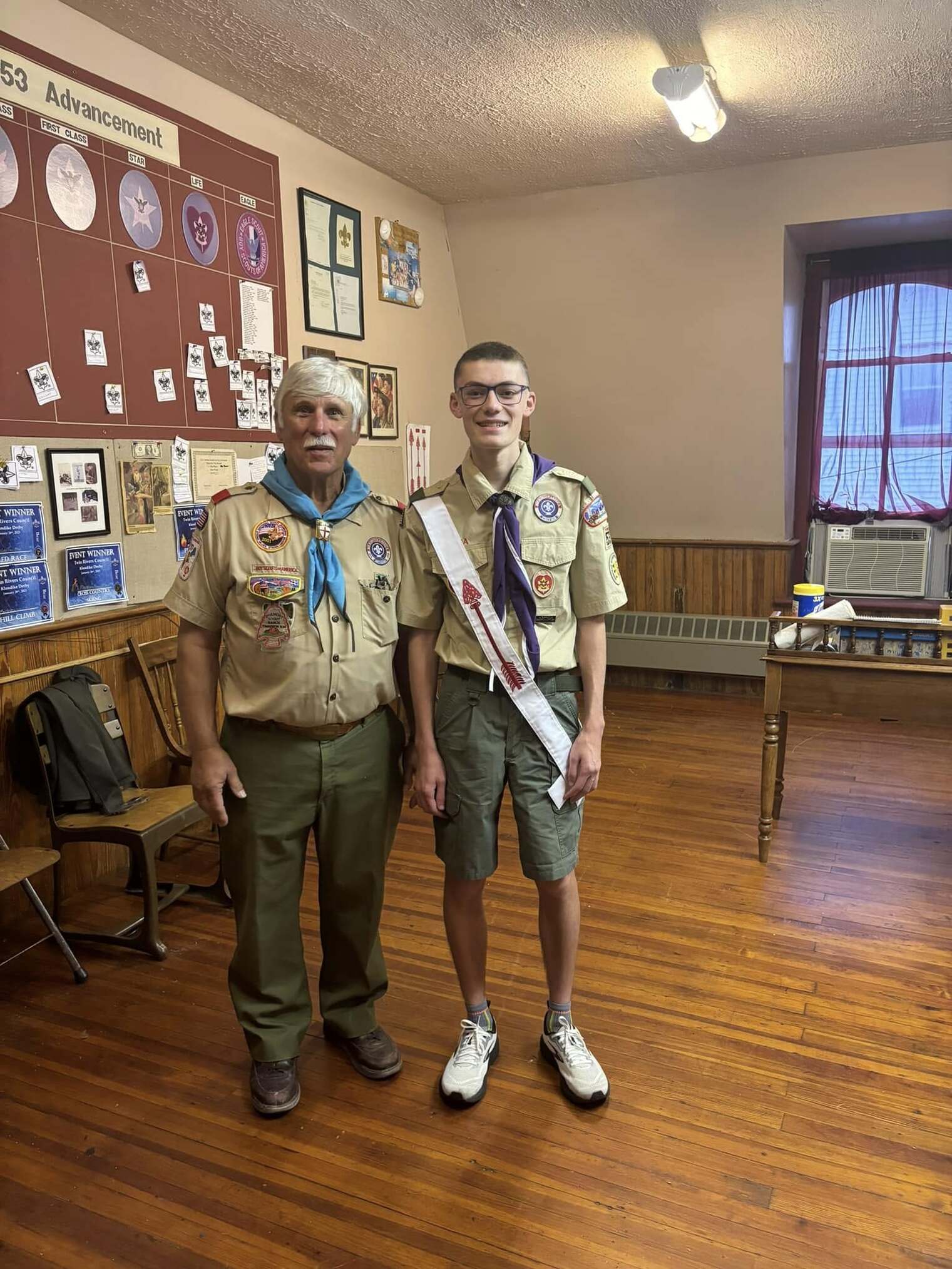 Two people smiling at the camera wearing class A uniforms.
