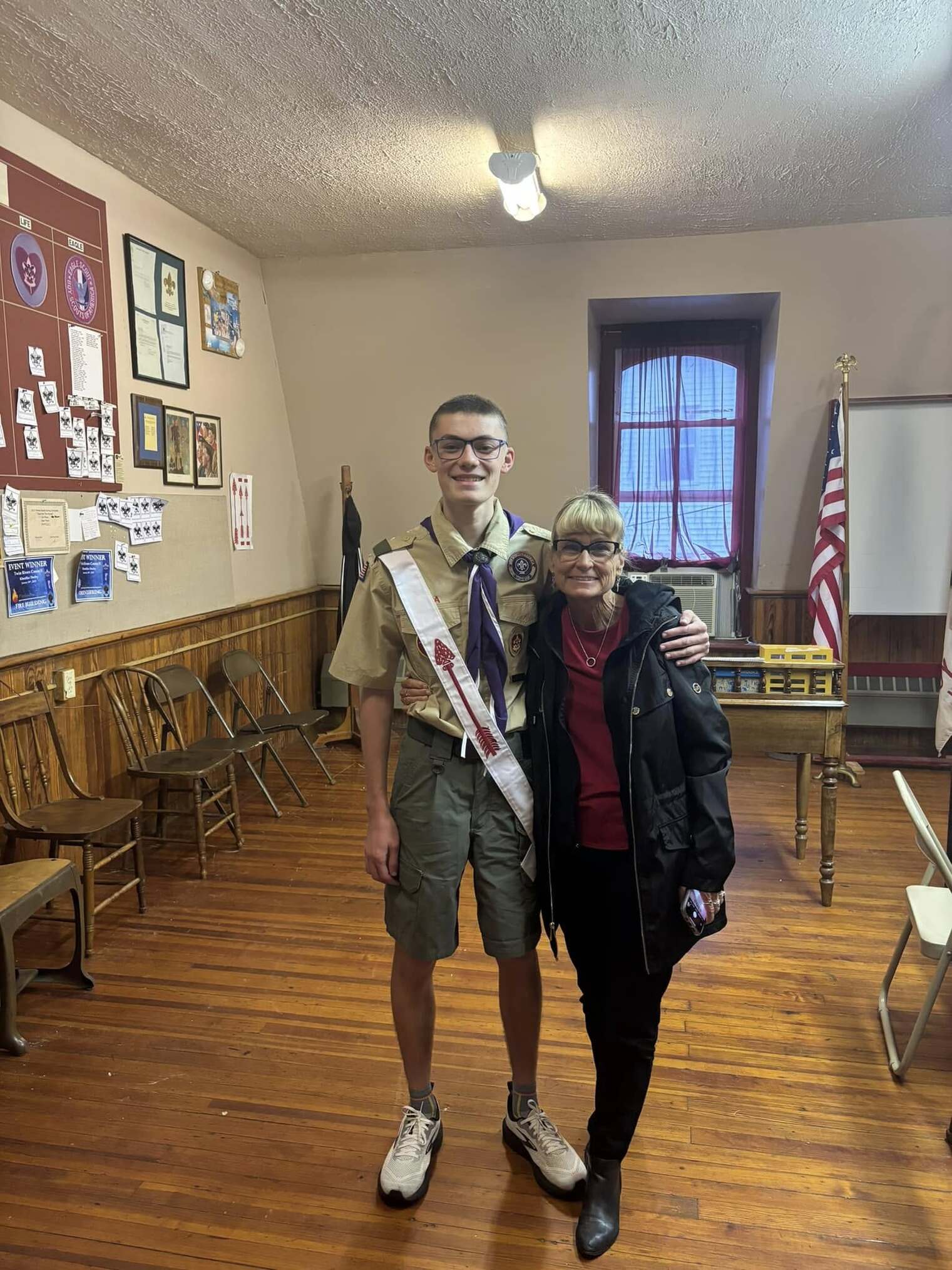 Two people in facing the camera.  The one on the left is in a Class A uniform.