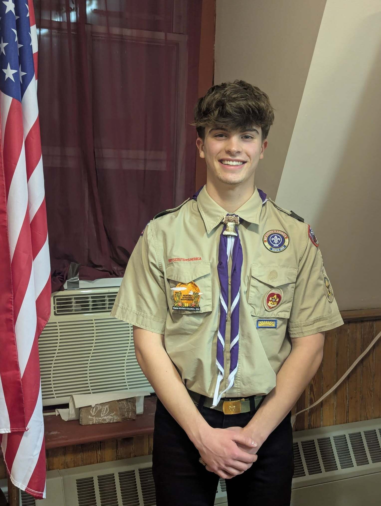 Ben stands next to an American flag.