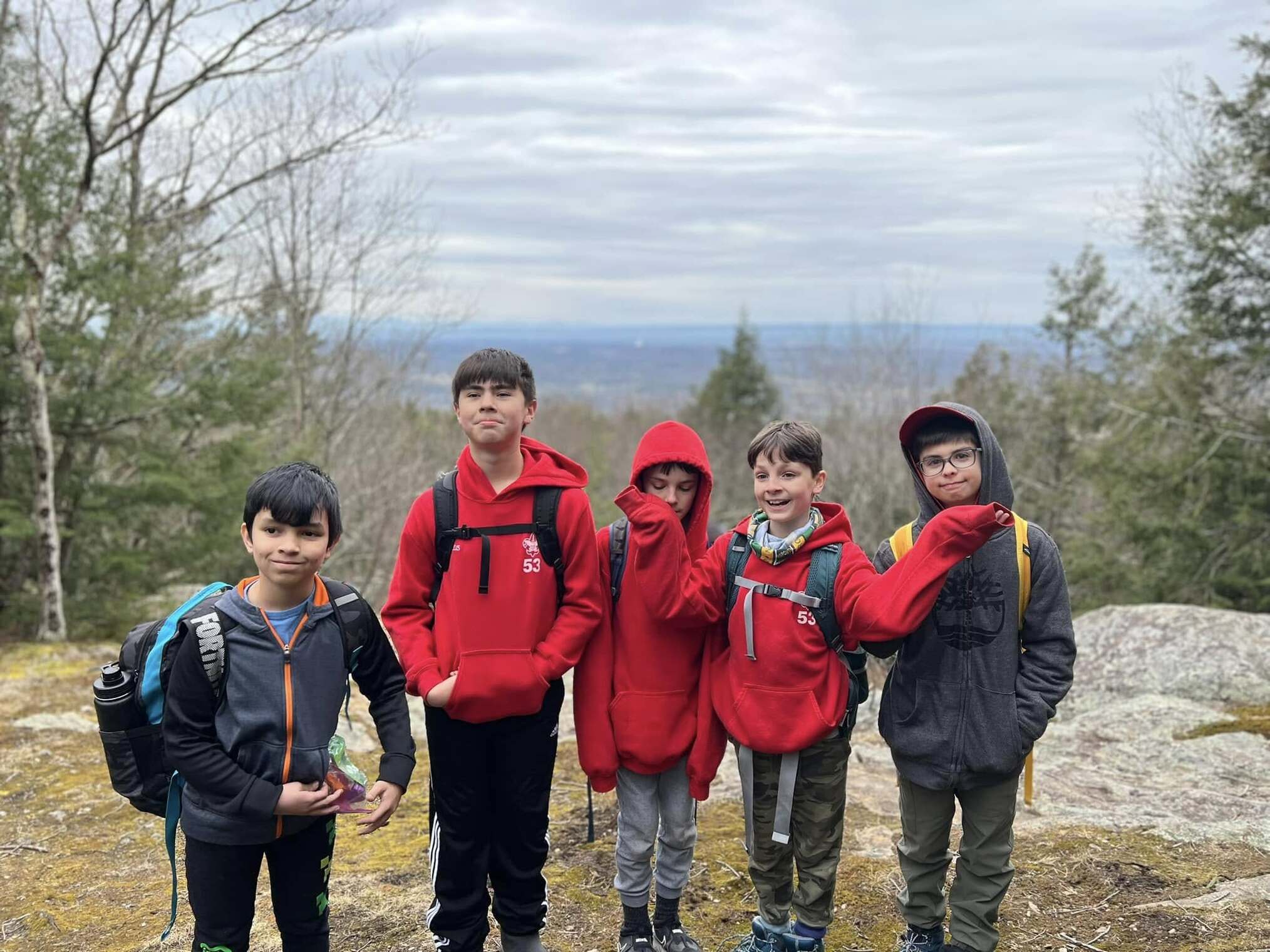 Five scouts smiling for the camera, with the Rotary cliffs in the background.