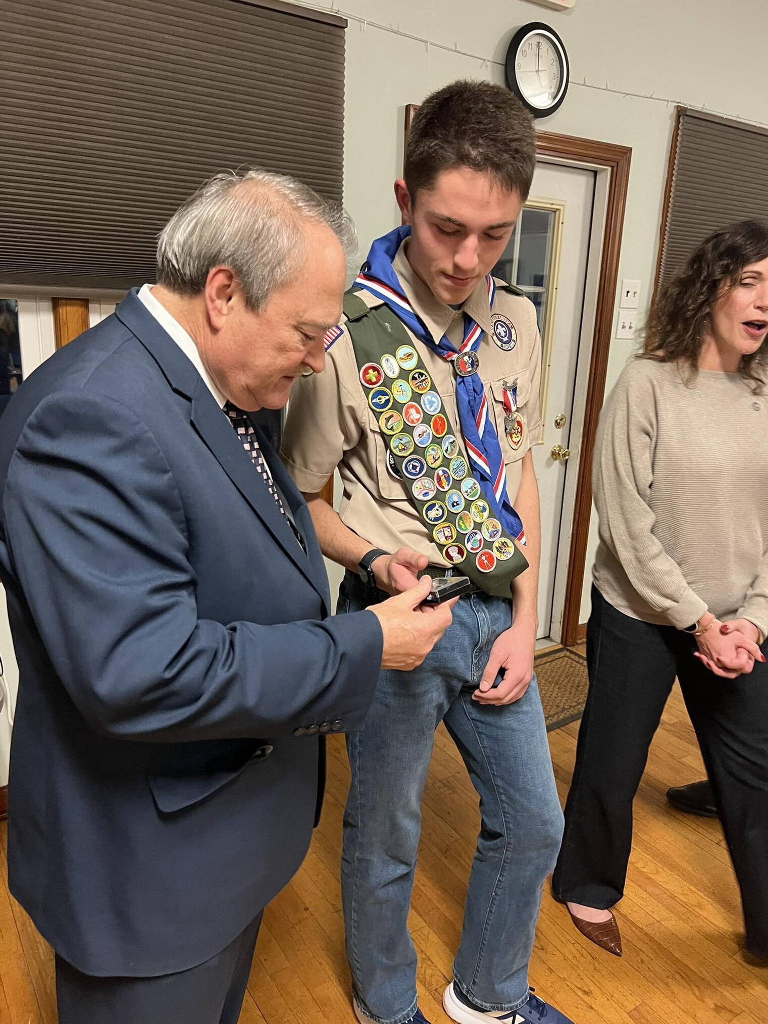 An older man seems to be giving something to Liam.